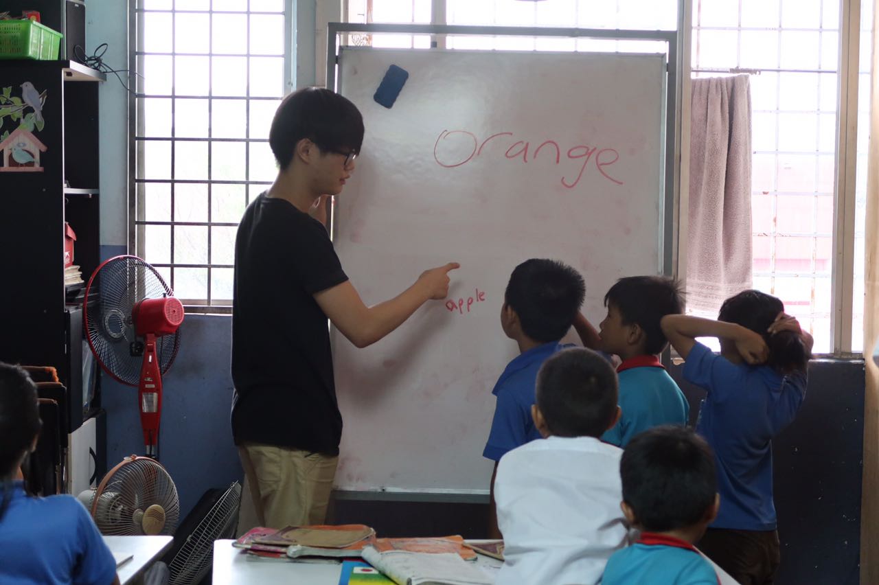 Photo of Yuzhe Lim teaching english language to refugee children